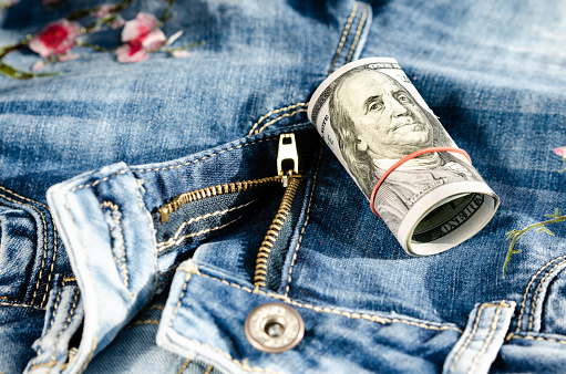 100 dollars on the on the zipper of jeans . Concept of prostitution , bribery or money laundering . Migration connected with trafficking in women and exploitation.